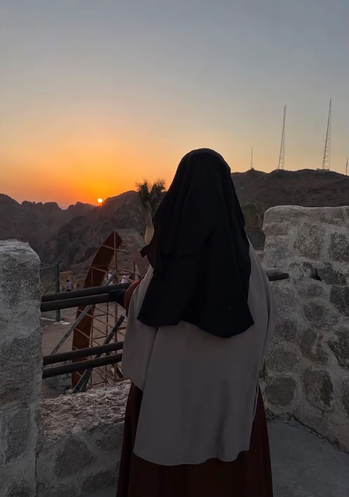 Een zuster kijkt uit over de bergen bij Medina tijdens zonsondergang
