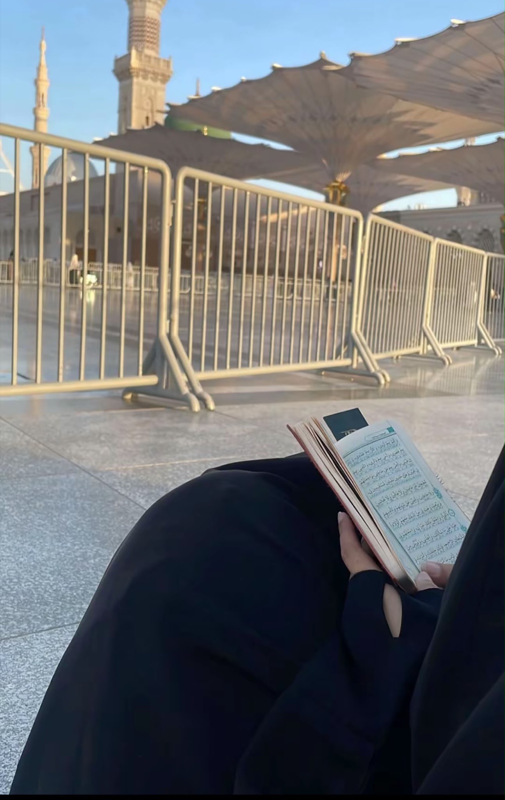 Een zuster leest de Qur'an op het plein van Masjid an-Nabawi